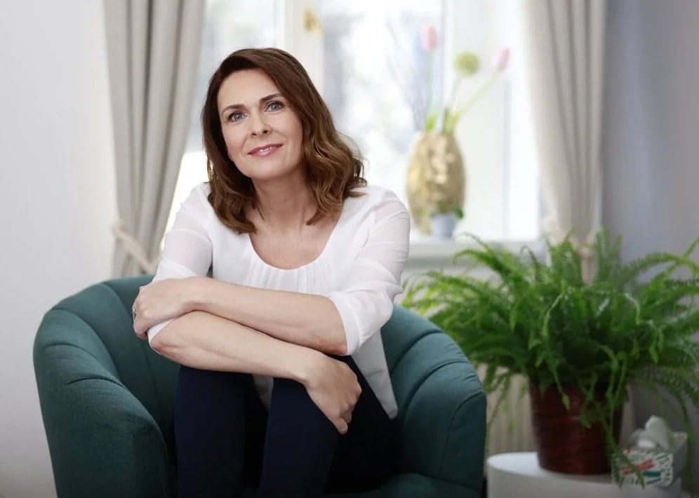 Frau sitzt entspannt auf grünem Sessel, schaut freundlich in die Kamera, helle, wohnliche Umgebung – Businessportraits von Claudia Masur aus Leipzig mit natürlicher Atmosphäre